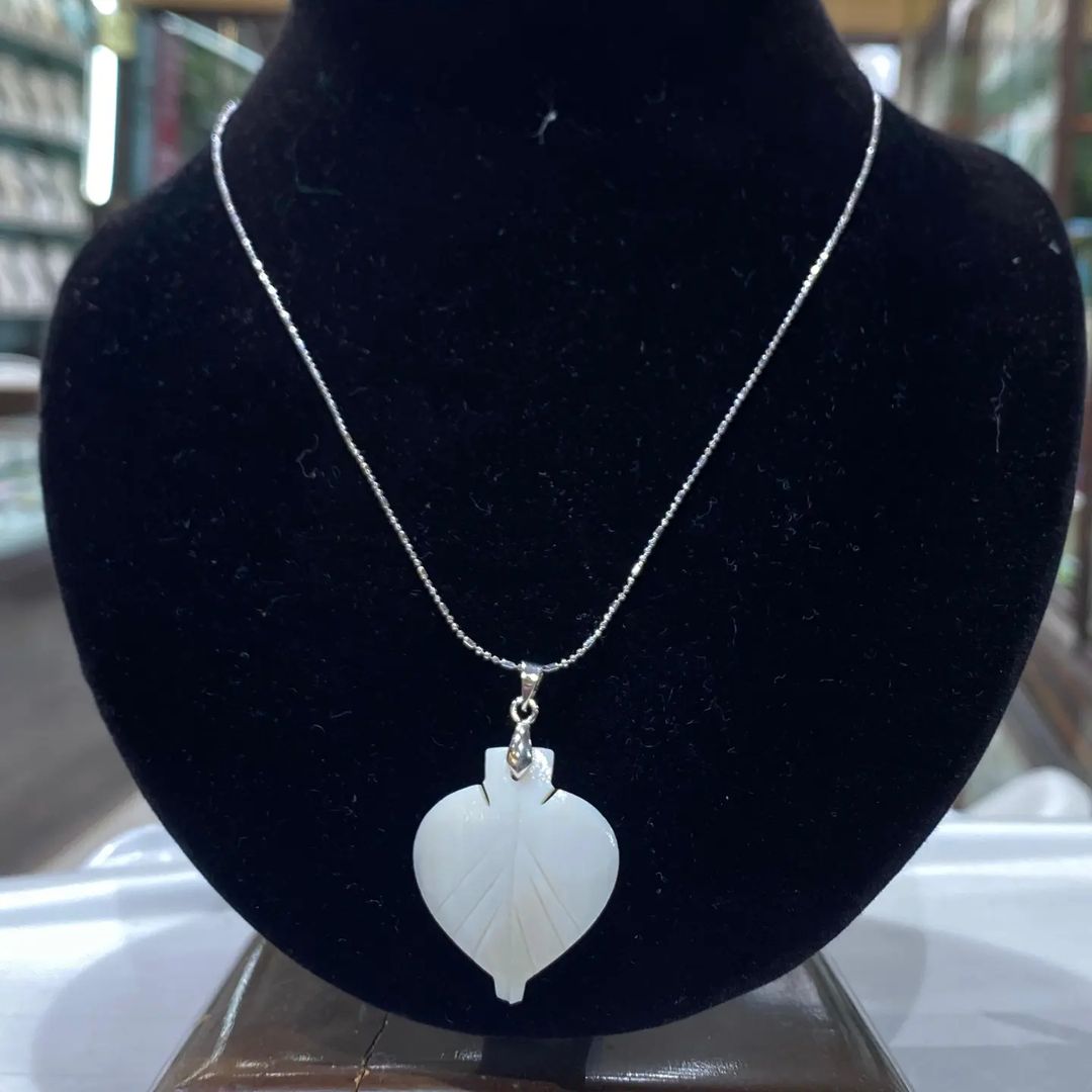 Elegant shell locket with a pearl accent, perfect for a beachy yet sophisticated look.