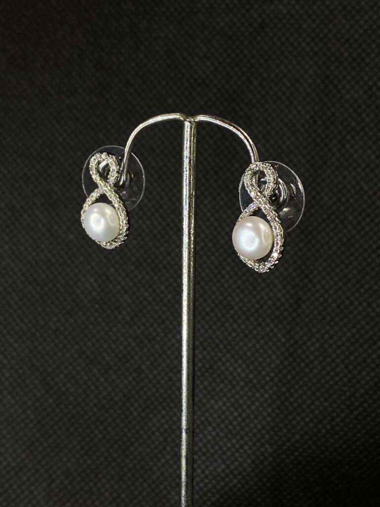 Infinity Pearl Studs with a modern infinity design and central pearl.