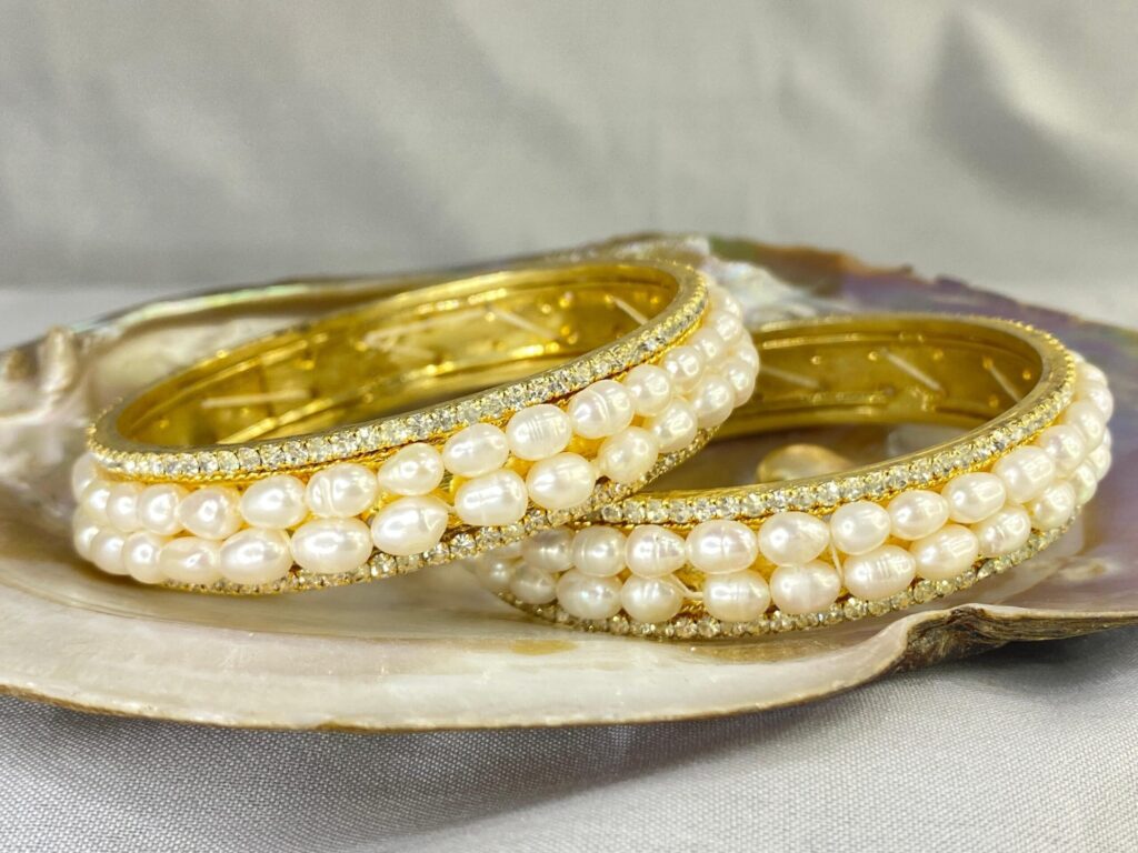 Double Line Pearl Bangle featuring two rows of lustrous pearls set in an elegant and sophisticated design.