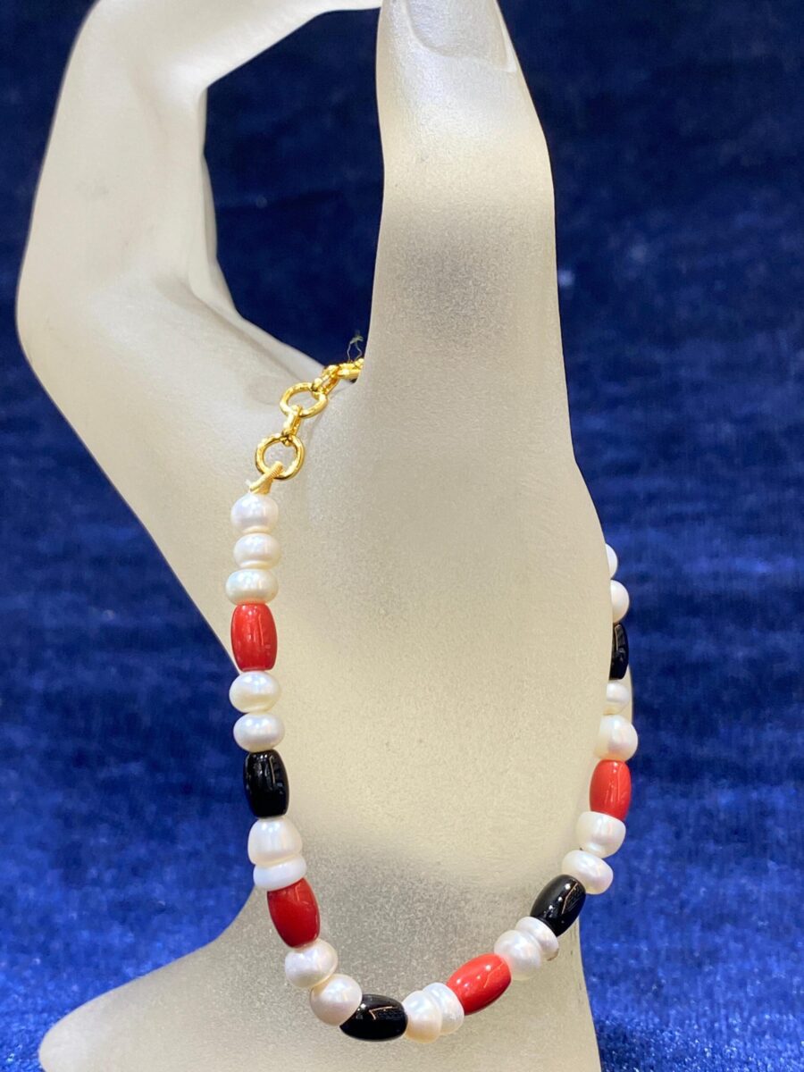 Pearl Coral and Onyx Bracelet featuring pearls, vibrant coral stones, and bold onyx accents in an elegant design.