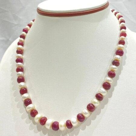 Beautiful gradation pearl necklace with ruby accents, perfect for a sophisticated evening look.