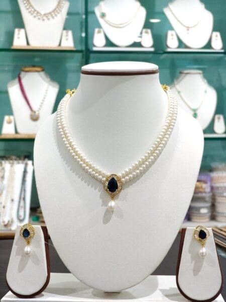 Elegant double line pearls set featuring a stunning dark blue pendant, perfect for adding a touch of sophistication to any occasion.