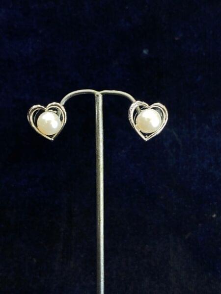 Heartfelt Pearl Studs featuring a heart-shaped design with pearls.