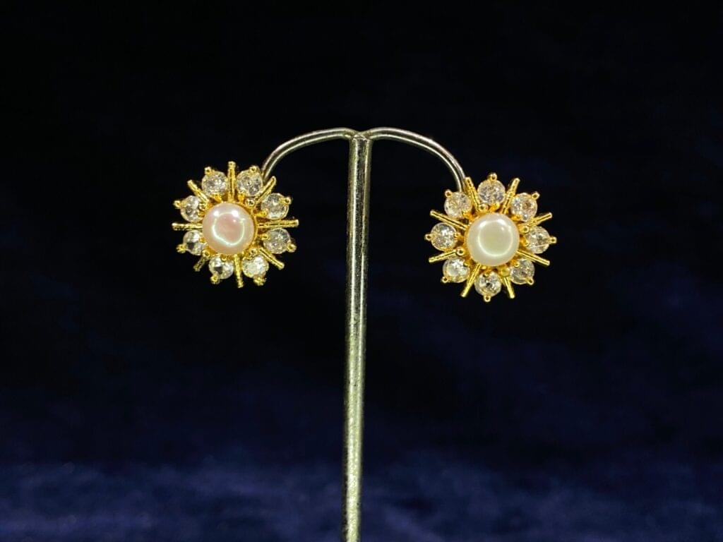 Pearl Sunburst Tops featuring a radiant sunburst design with a central pearl.