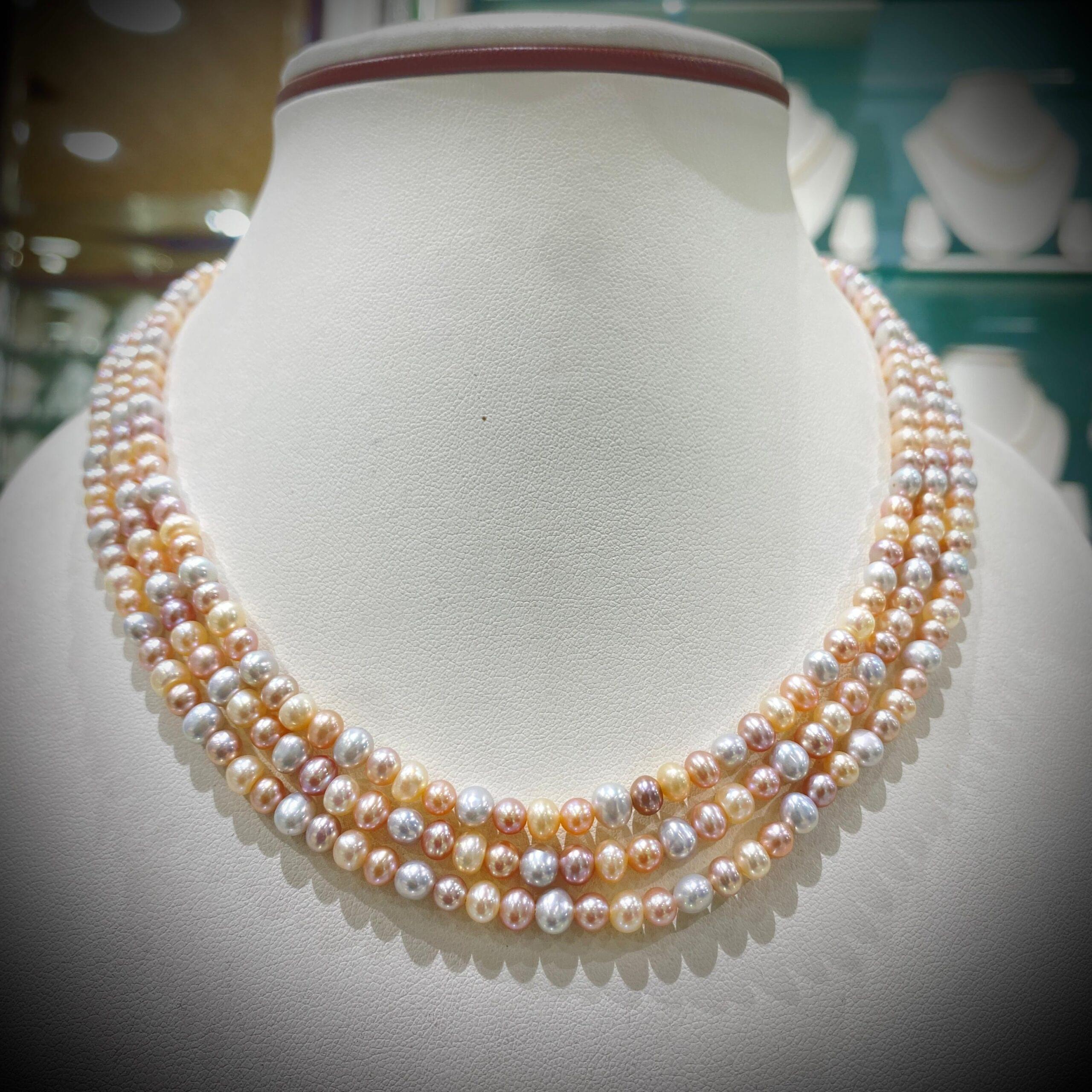 Elegant Three-Strand Pastel Pearl Necklace with soft pastel hues, perfect for any occasion.